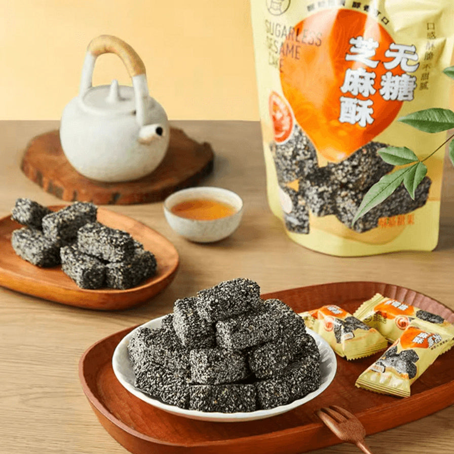 木质桌面上的下午茶场景，包含盒马无糖芝麻酥、独立小包装、茶壶和茶杯。