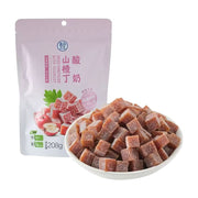 盒马酸奶山楂丁208g包装袋，前方摆放一碗装满的方形山楂丁，展示产品实物。