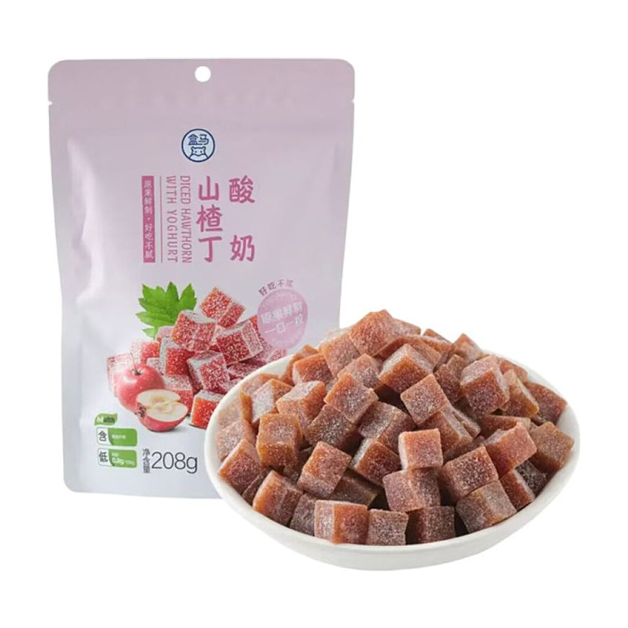 盒马酸奶山楂丁208g包装袋，前方摆放一碗装满的方形山楂丁，展示产品实物。