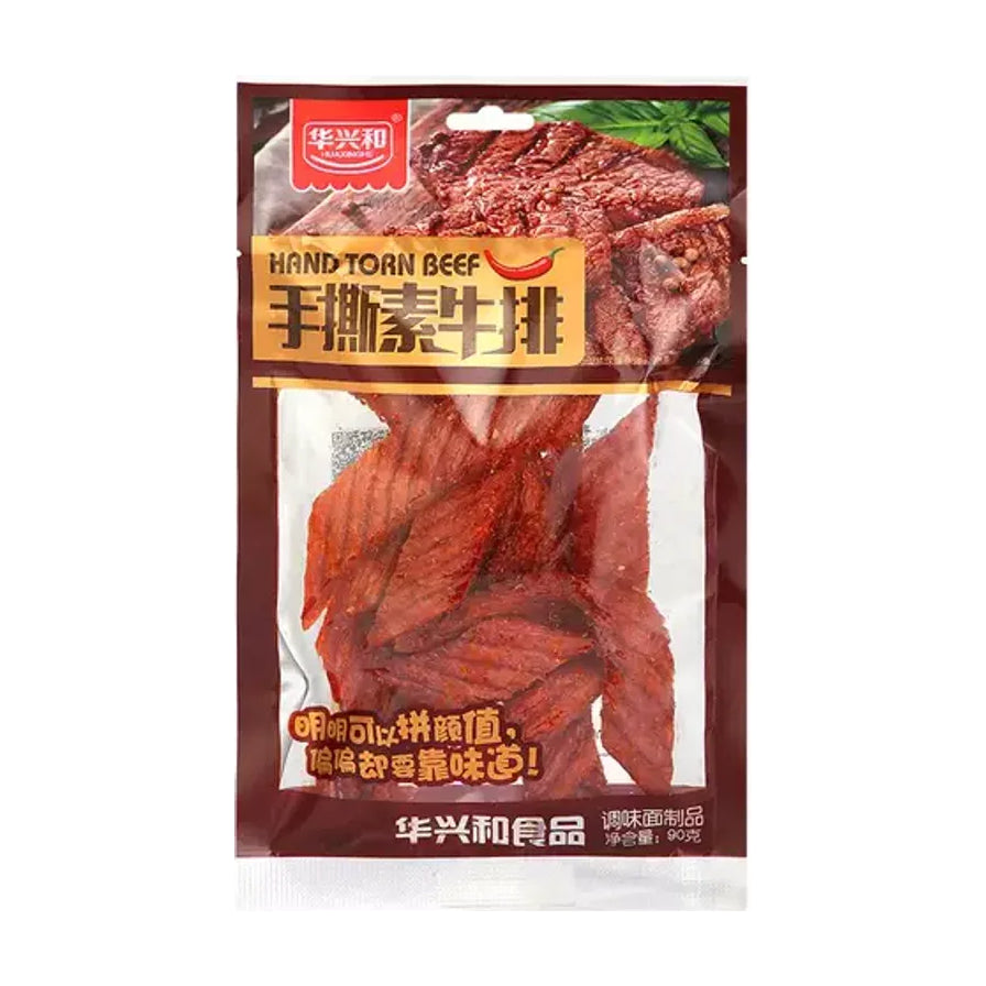 华兴和手撕素牛排包装正面图，透明包装可见内部红油浸润的片状辣条，包装上有手撕素牛排字样。