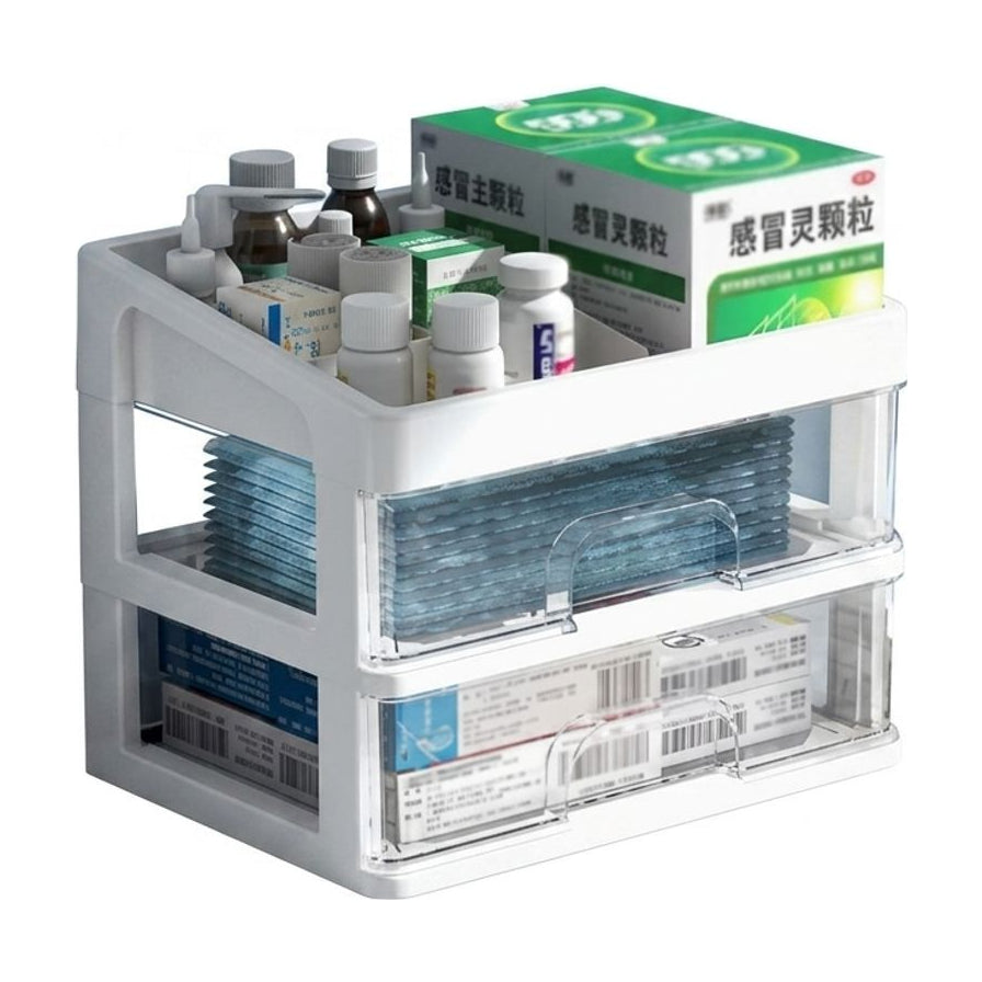 白色三层抽屉式药箱正面图，顶部开放格放置药瓶和感冒灵颗粒盒，下方两层为透明可视抽屉，内含蓝色口罩和药盒。