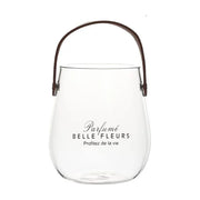 日式手提透明玻璃花瓶，瓶身印有Parfumé BELLE FLEURS英文字样，配有棕色皮质感提手，简约大方。