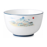 白色背景下的日式釉中彩陶瓷面碗，碗身印有淡雅的山水画图案，碗口边缘带有蓝色线条装饰。