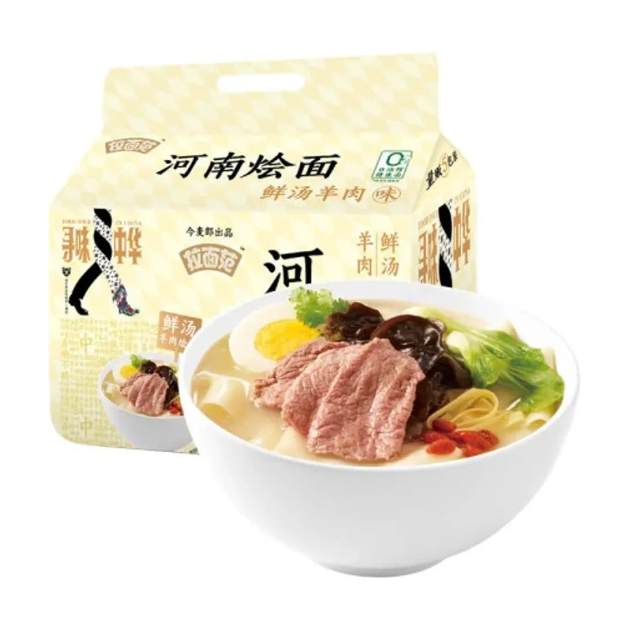 一碗热气腾腾的今麦郎河南烩面，配有羊肉片、木耳、枸杞和青菜，背景为产品大包装。