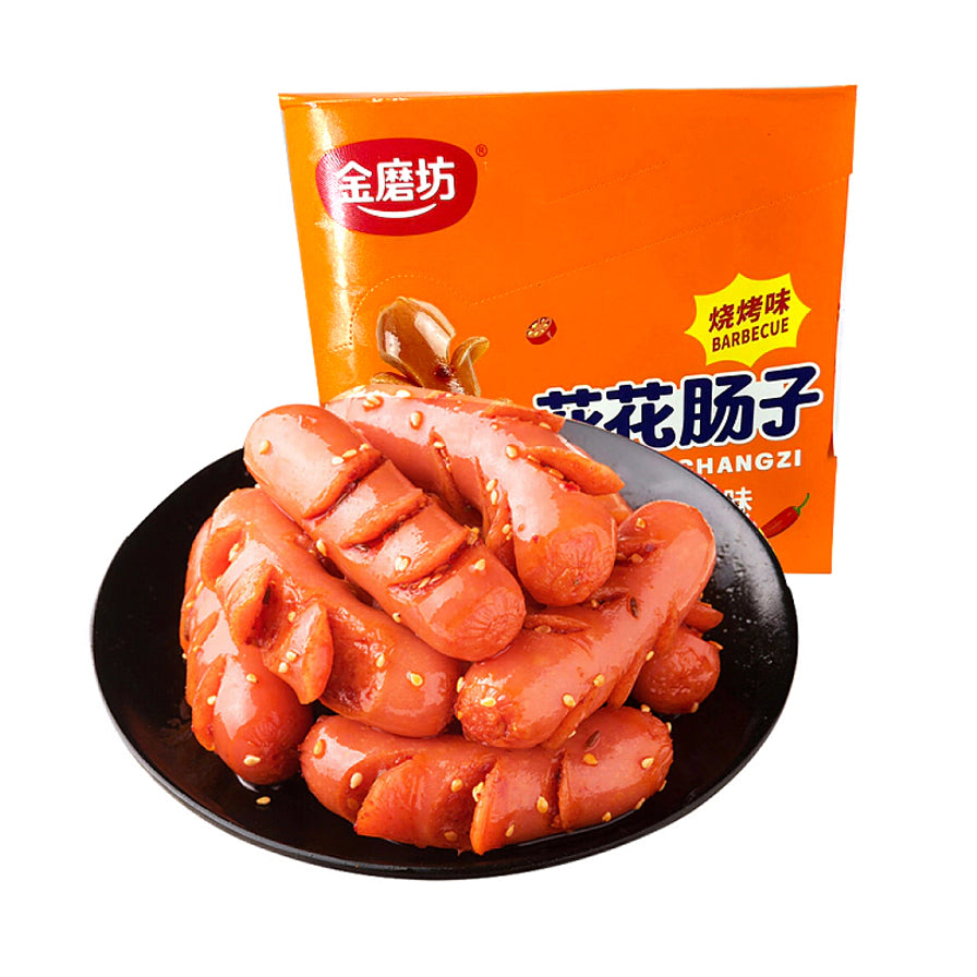 黑色盘中盛放的切花烧烤味小香肠，背景为橙色包装盒