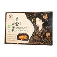 禧月阁黑金凤梨酥包装盒，黑色背景印有古风仕女图，展示了切开的黑金凤梨酥，可见天然墨鱼汁外皮、凤梨内馅和海鸭蛋黄。