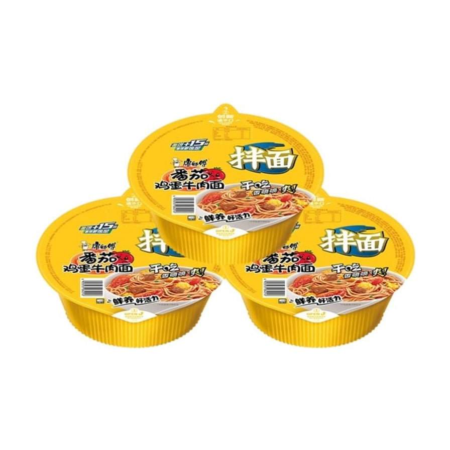 三碗康师傅番茄鸡蛋牛肉干拌面，黄色碗装设计，包装上印有番茄和牛肉面图案。