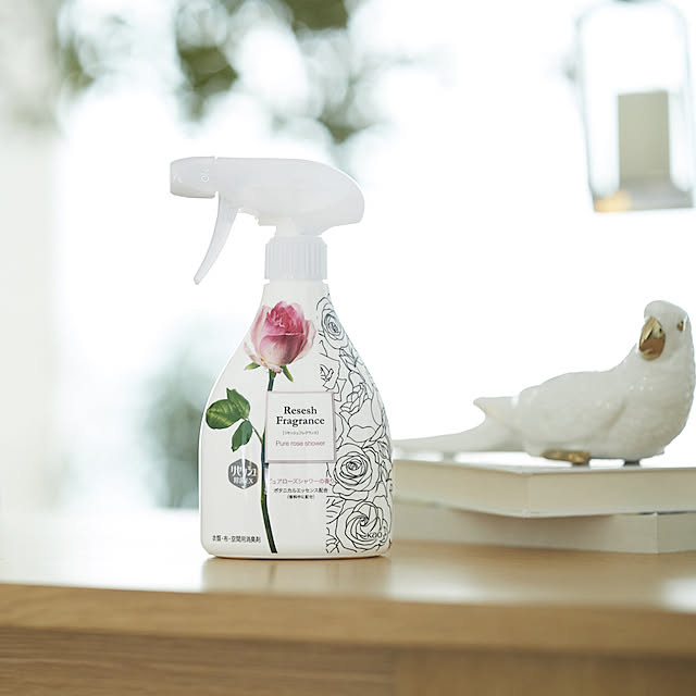 花王 Resesh 消臭喷雾放置在木质桌面上，背景有模糊的窗户和白色小鸟摆件的生活场景图。