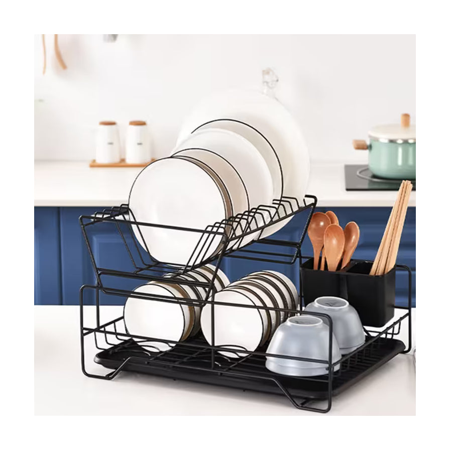 厨房台面上的黑色双层沥水架，摆放着盘子和碗，右侧放置筷子筒，背景为蓝色橱柜。