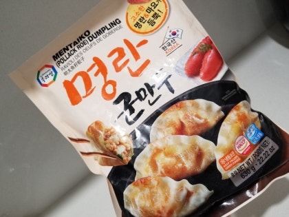 煎锅中金黄酥脆的韩式饺子特写，展现烹饪后的诱人色泽