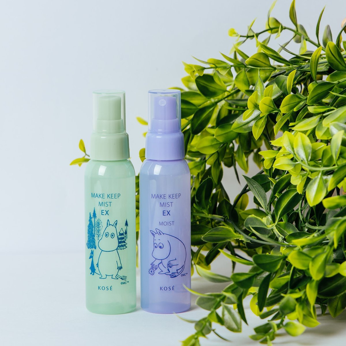 高丝 Kose Moomin 联名款定妆喷雾绿色与紫色两款瓶身并排展示的生活场景图。