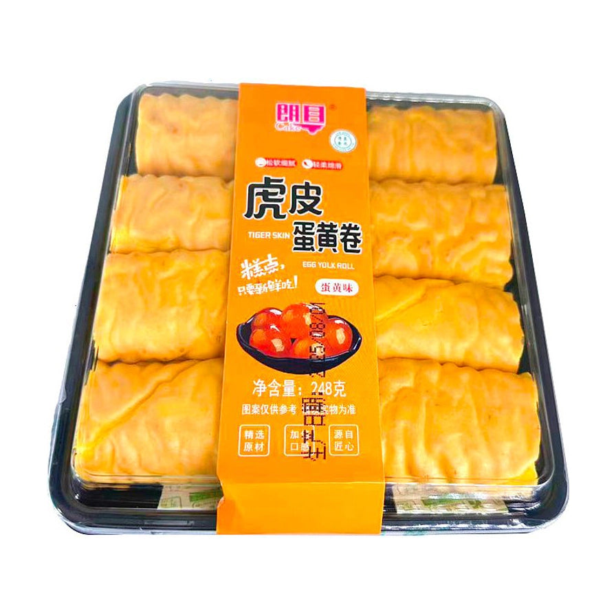 朗目虎皮蛋黄卷蛋黄味俯拍图，透明盒装内含四支金黄色蛋糕卷，橙色腰封印有品牌及口味信息。