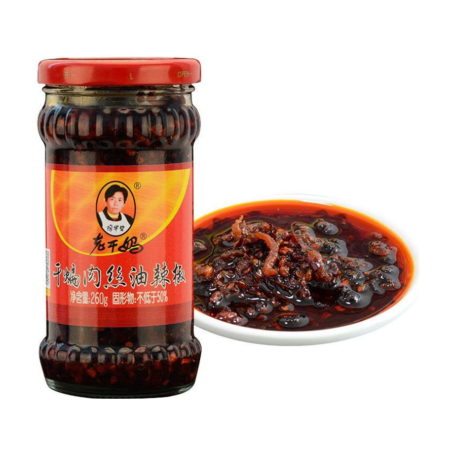 老干妈干煸肉丝油辣椒瓶装及一碟盛出的油辣椒，展示丰富的肉丝和辣椒油质感。