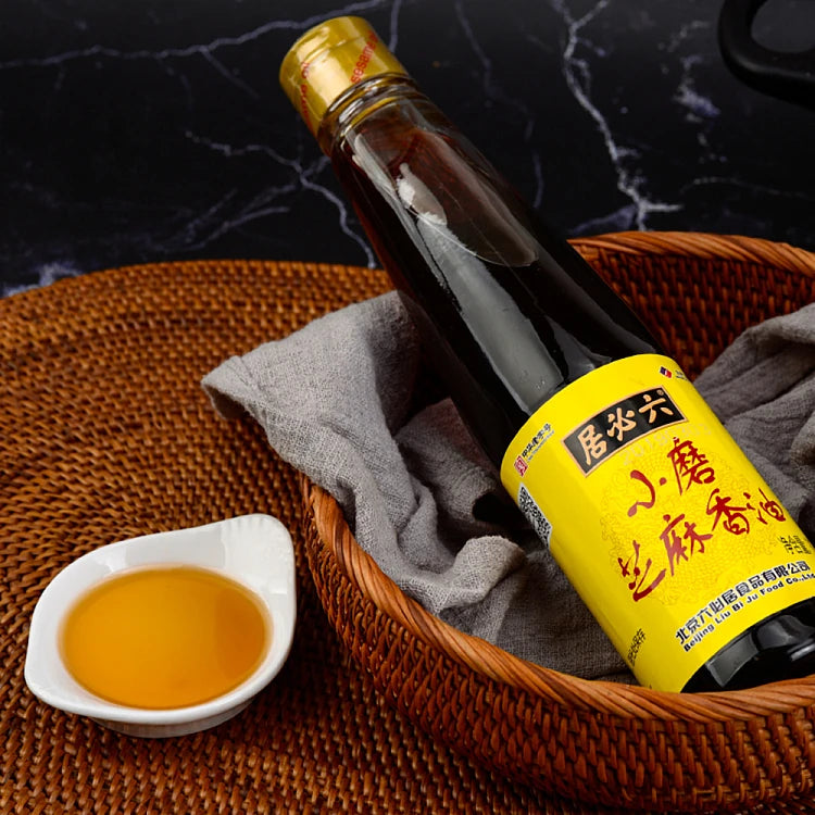 六必居小磨芝麻香油瓶身特写，展示玻璃瓶包装与产品标签细节