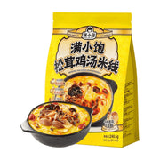 满小饱松茸鸡汤米线黄色包装袋，前方摆放一碗盛满松茸、菌菇和红枣的浓郁鸡汤米线。
