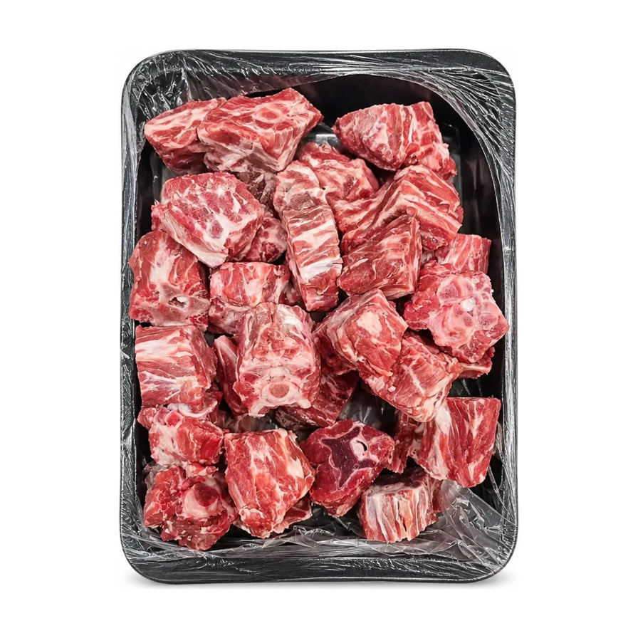 黑色托盘中整齐摆放的新鲜生羊蝎子块，肉质红润，带有白色大理石纹理脂肪，覆盖有透明保鲜膜，白色背景。