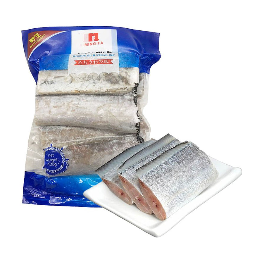 明发野生带鱼段 400g 产品包装及盘中解冻后的鱼肉展示，银色鱼皮完整，肉质紧实。