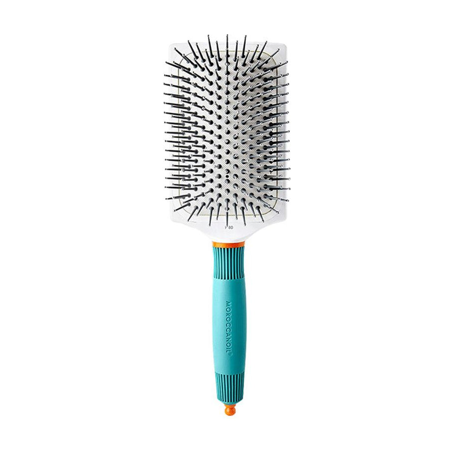 Moroccanoil 摩洛哥油陶瓷离子气垫梳正面特写，展示白色梳头、黑色梳齿及蓝绿色防滑手柄细节。