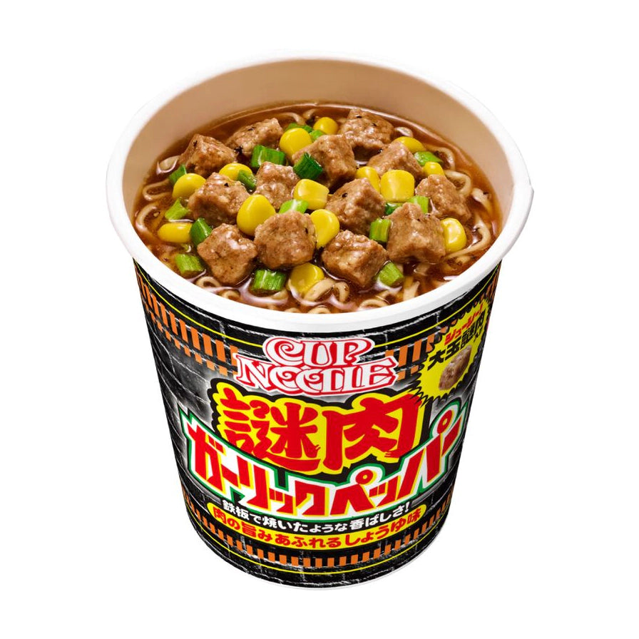 日清蒜香胡椒大块肉拉面俯视图，杯面内可见大块肉粒、玉米和葱花，包装印有日文品牌标识。