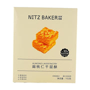 尼茨焙客扁桃仁千层酥102g盒装正面图，包装上印有两块叠放的千层酥实物图，并标注大于30%黄油添加量。
