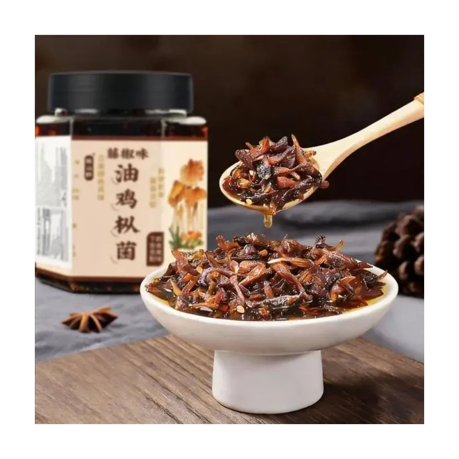 致山野油鸡枞菌酱食用场景图，木勺舀起一勺深色菌酱置于白瓷碗上方，背景为产品包装瓶。