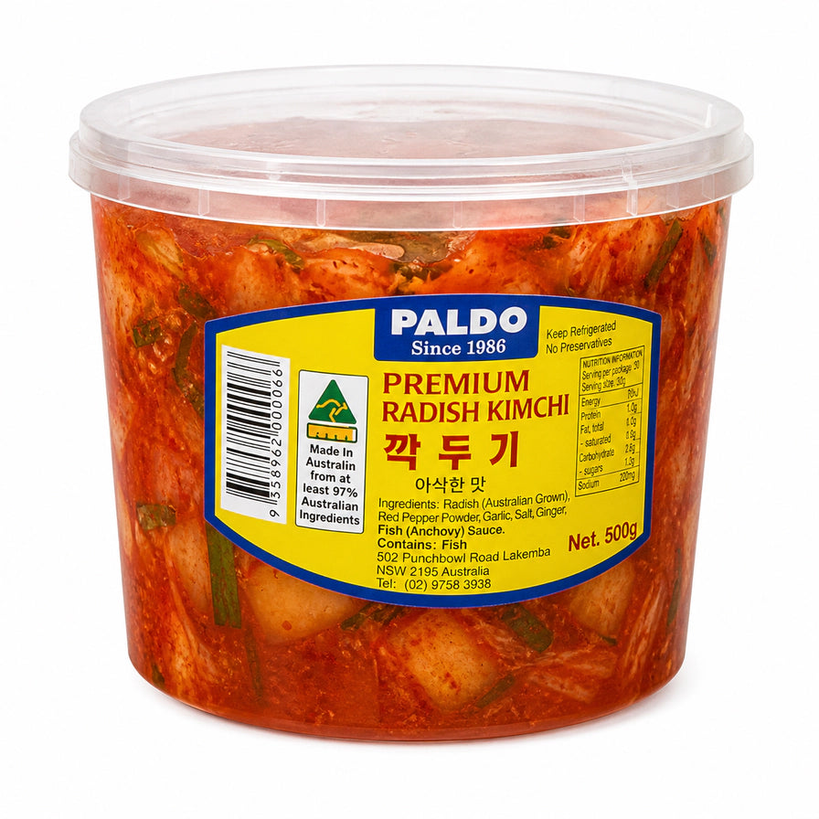 Paldo 品牌 500g 桶装辣泡菜，透明桶装展示切块均匀的红色辣味泡菜，黄色标签清晰可见。