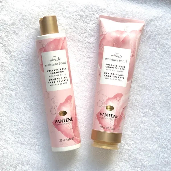 潘婷奇迹保湿玫瑰水洗发水和护发素套装平铺图，置于白色毛巾上。