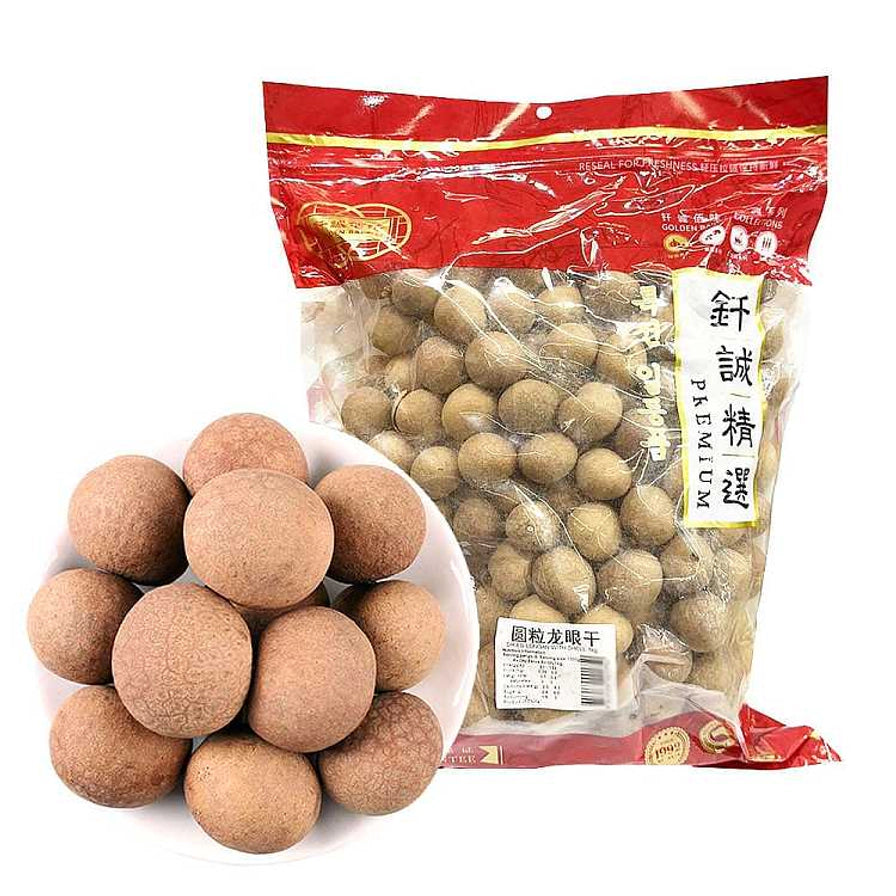 一盘圆润饱满的带壳龙眼干与钎诚圆粒龙眼干100g包装袋的合影，展示了产品的实际外观。