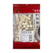 钎诚特级茯苓粒100g透明袋装正面图，可见白色方块状茯苓颗粒及营养成分表标签。