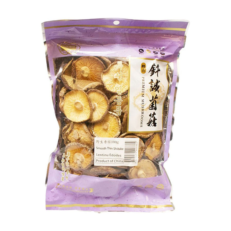 钎诚香信紫色包装袋，透明窗口可见内部干燥完整的香信菌菇，背景为木质桌面及竹筐盛放的香菇。