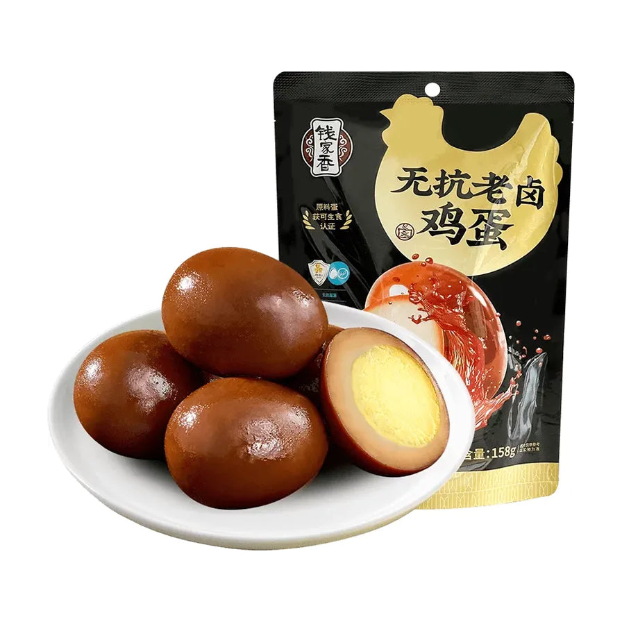 钱家香无抗老卤鸡蛋包装袋与白瓷盘中剥壳后的卤蛋，展示深褐色Q弹蛋白与绵软蛋黄切面。