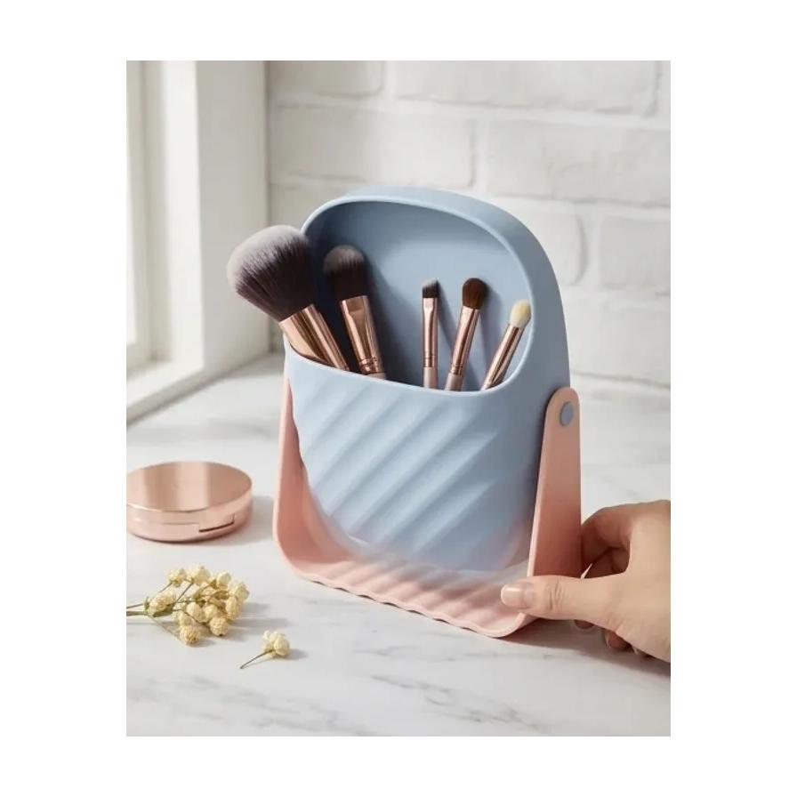 大理石台面上的生活场景图，一只手正在转动装满化妆刷的收纳桶，旁边放有粉饼和干花。