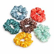 七款不同颜色的缎面发圈平铺展示，包含蓝色、红色、绿色、棕色、黄色和薄荷绿。