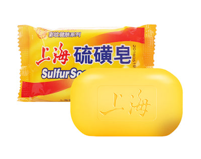 拆封后的黄色硫磺皂实物与包装袋展示，皂体表面刻有品牌字样。