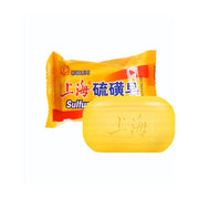 上海硫磺皂产品图，展示黄色包装纸与一块刻有“上海”字样的黄色香皂。