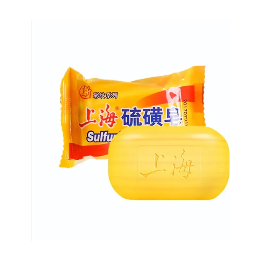 上海硫磺皂产品图，展示黄色包装纸与一块刻有“上海”字样的黄色香皂。