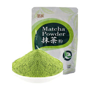 圣家抹茶粉100g袋装，前方是一小碟细腻的翠绿色抹茶粉末，背景为白色。