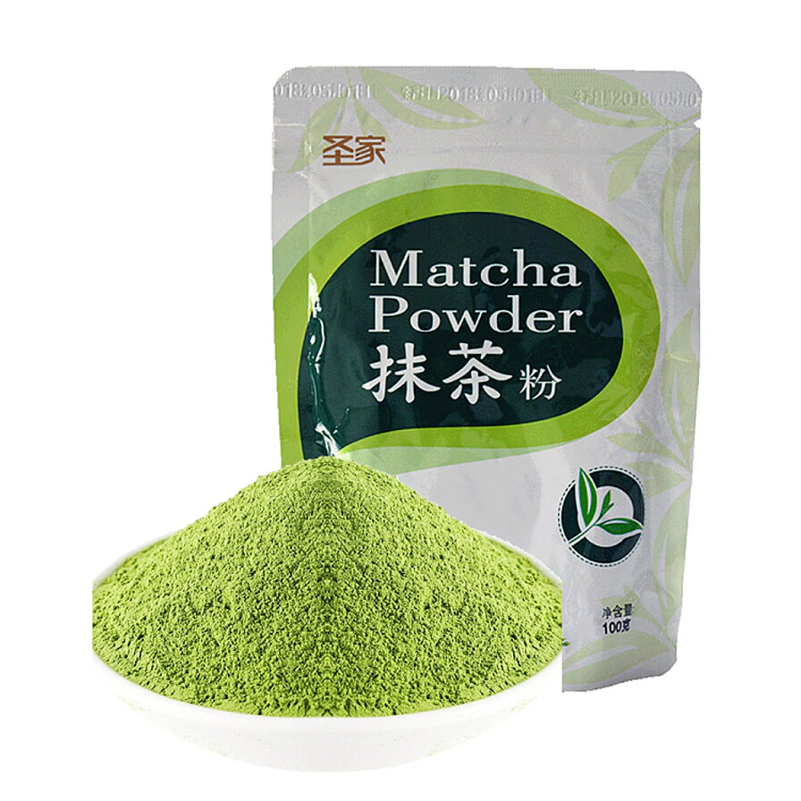 圣家日式抹茶粉，前景为一堆细腻的绿色抹茶粉末，背景为100g自封袋装产品。