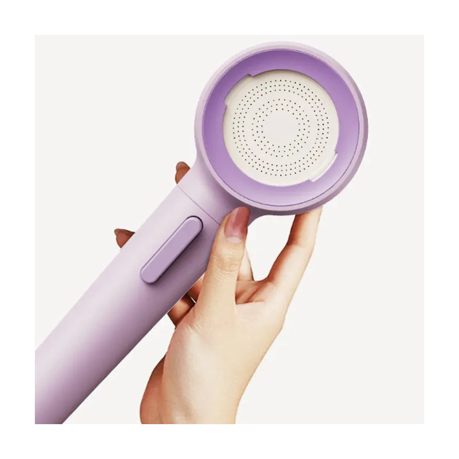 手持苏泊尔紫色增压花洒的近距离特写，展示细密的出水孔面板和侧面按键。