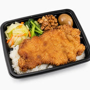 古早味排骨便当盒，包含一大块金黄酥脆的炸排骨、白米饭、卤蛋、青菜和配菜，采用黑色长方形便当盒盛装。