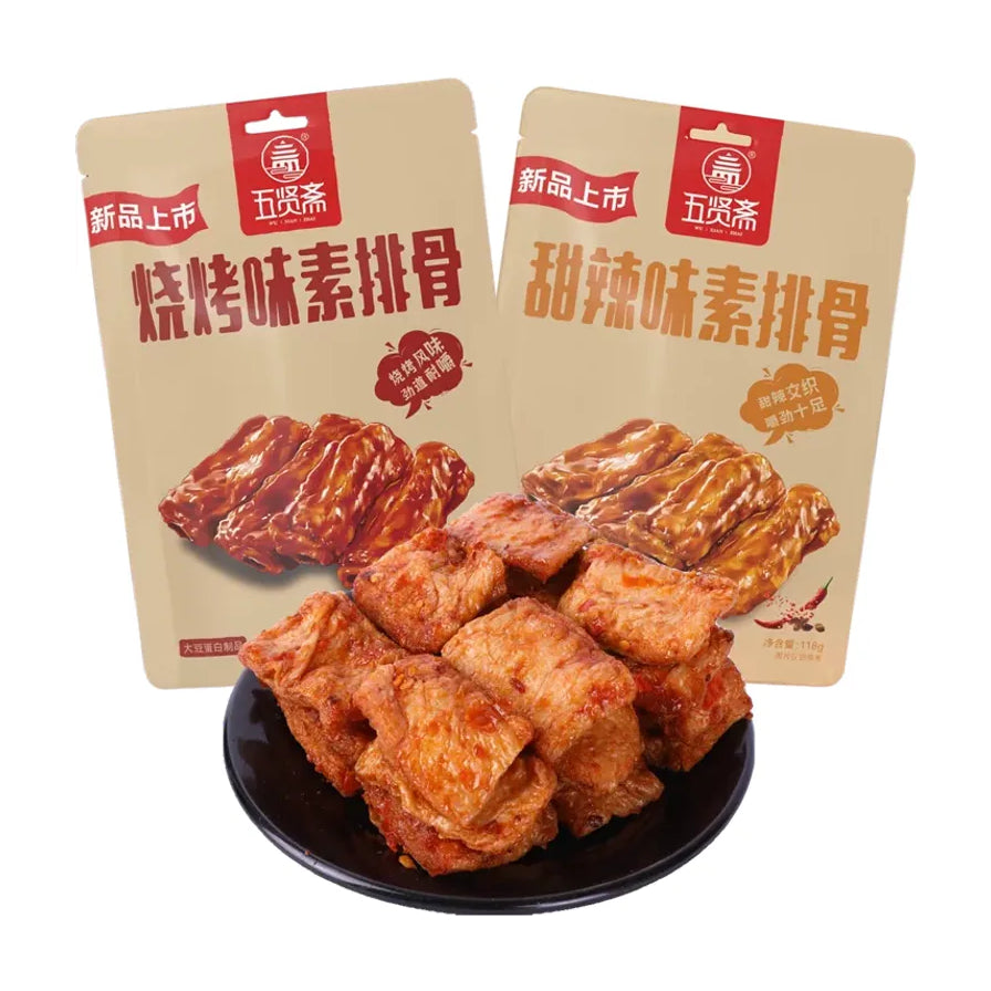 两包五贤斋素排骨（烧烤味与甜辣味）包装展示，前方黑色盘中盛放着块状大豆蛋白素食。