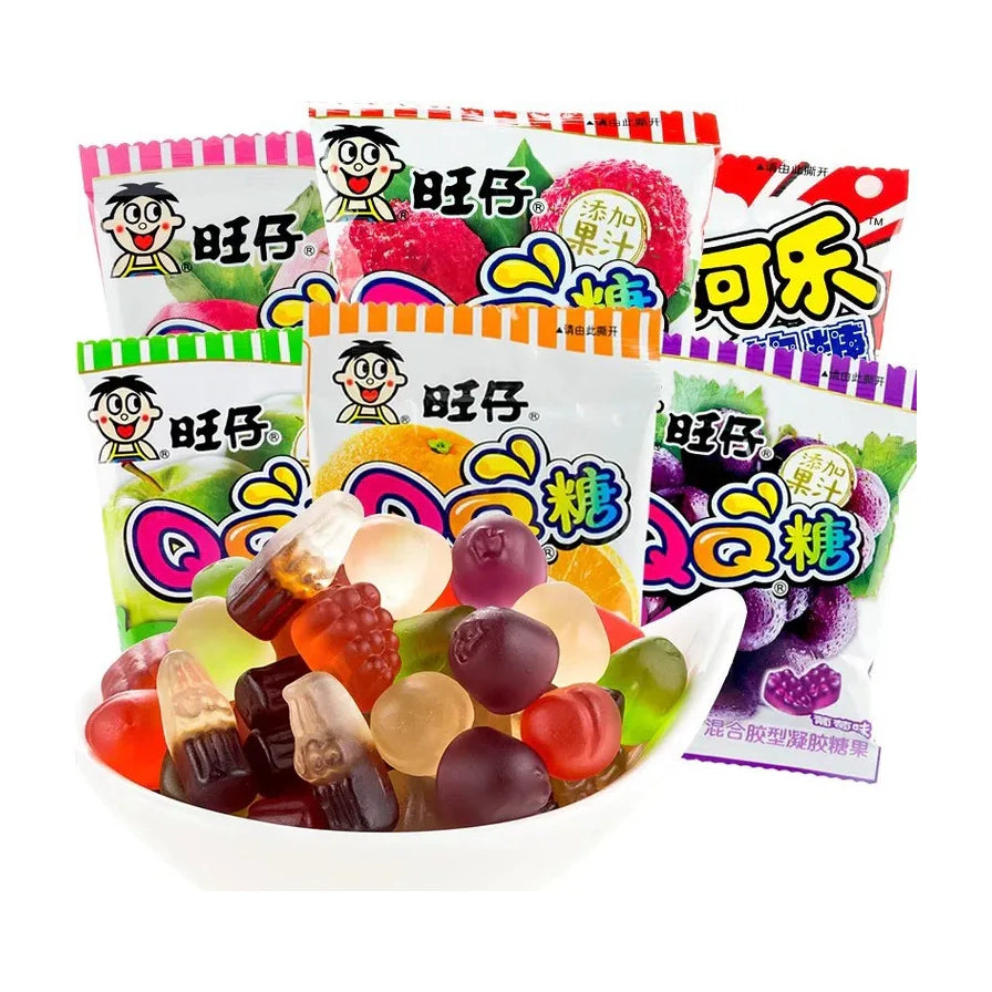 旺旺旺崽QQ糖多种口味组合，包含草莓、荔枝、可乐、香橙、葡萄、苹果等包装，前景为一碗晶莹剔透的各色果汁软糖。