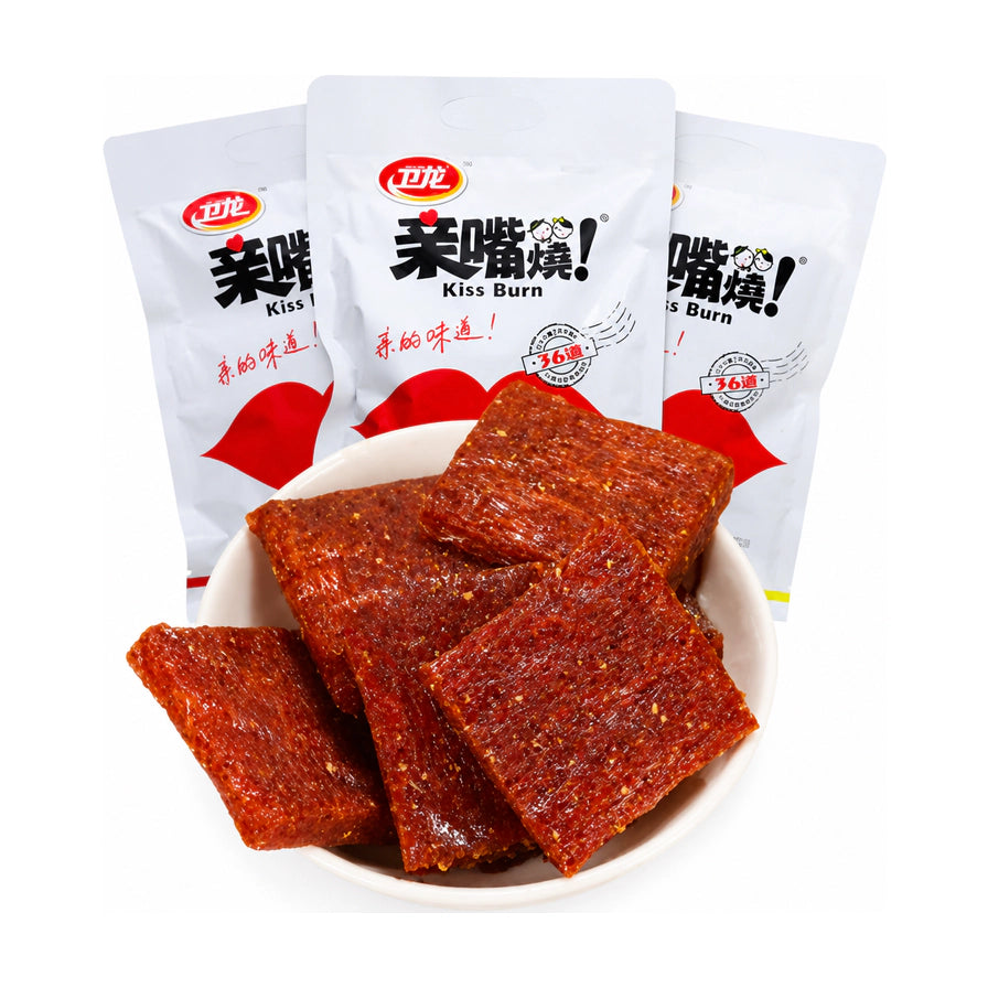 白色小碗中盛放着数片卫龙亲嘴烧辣条，背景是三袋白色包装的亲嘴烧，展示经典方块造型。