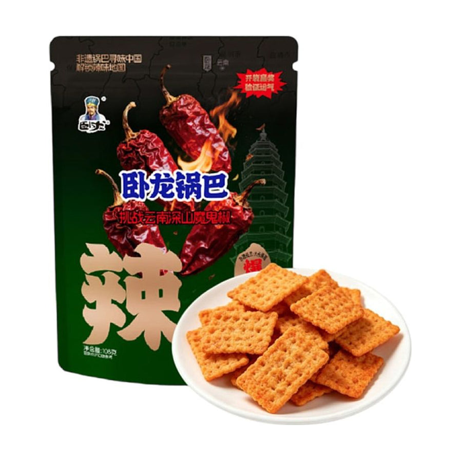 卧龙锅巴魔鬼爆辣口味包装袋，配有一盘金黄酥脆的方形手工锅巴，背景带有辣椒和火焰元素。
