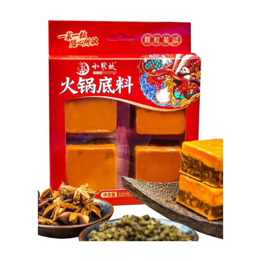 小龙坎火锅底料包装盒展示，透过透明窗口可见内部四粒底料，前景配有八角、花椒等香料及切开的底料特写。