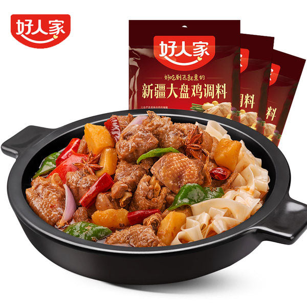 烹饪中的新疆大盘鸡特写，鸡肉土豆青红椒在浓郁酱汁中炖煮