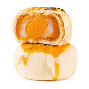 白色背景上叠放的两个心里话蛋黄酥，上方一个切开展示出咸蛋黄、拉丝麻薯和豆沙内馅，下方为完整金黄酥皮蛋黄酥。
