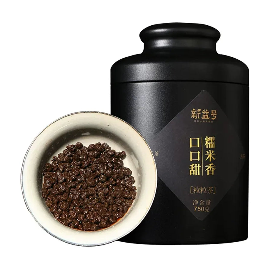 新益号糯香粒粒茶黑色金属罐装与一碗深褐色普洱茶粒，包装上印有口口甜糯米香字样。