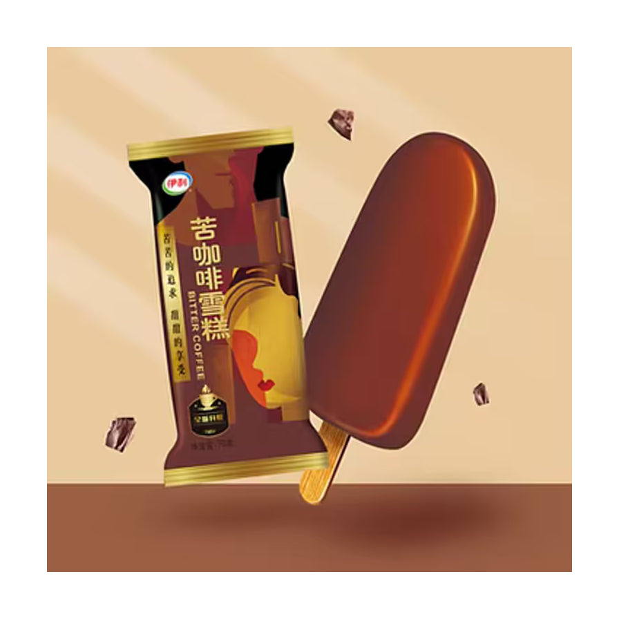 伊利苦咖啡雪糕产品特写，展示了深棕色脆皮雪糕本体及其包装袋，背景有巧克力碎屑点缀。