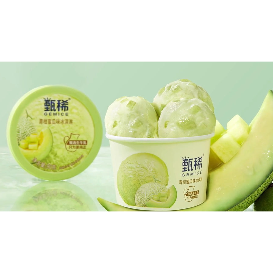打开后的伊利甄稀青柑蜜瓜味冰淇淋，杯中盛放着淡绿色冰淇淋球，背景点缀有新鲜蜜瓜块。